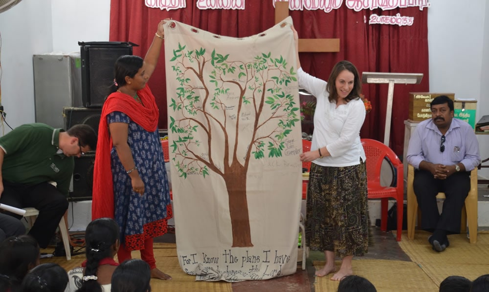 two people holding up a quilt